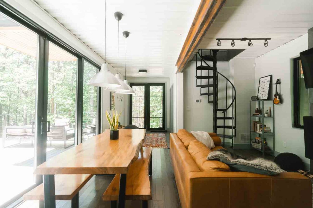 space-saving black metal spiral staircase in a modern living room with large windows